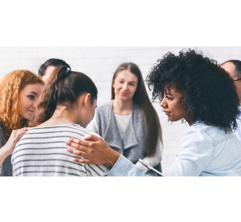 Photo d'un groupe de thérapie et de soutien émotionnel, une femme triste est soutenu par les autres pour illustrer l'accompagnement du groupe de thérapie émotionnelle