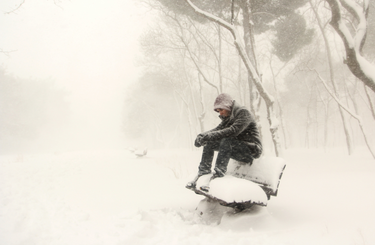 Photo d'un homme assis seul dans la neige et le froid pour illustrer la solitude et le repli sur soi dont on peut sortir en participant au groupe de thérapie émotionnelle animés par Amanda Tichit